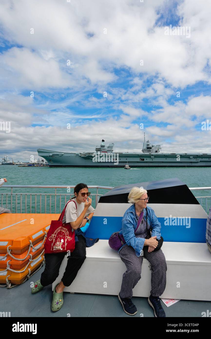 Touristen, die eine Bootsfahrt rund um den Hafen von Portsmouth genießen, sehen die Marineschiffe im Dock Hampshire England Großbritannien Stockfoto