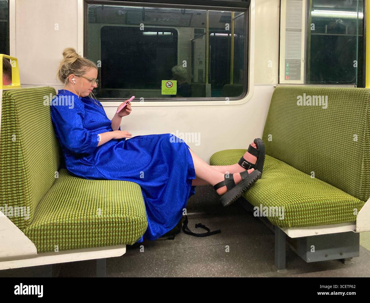 Person mit den Füßen auf dem Sitz im Zug Stockfoto