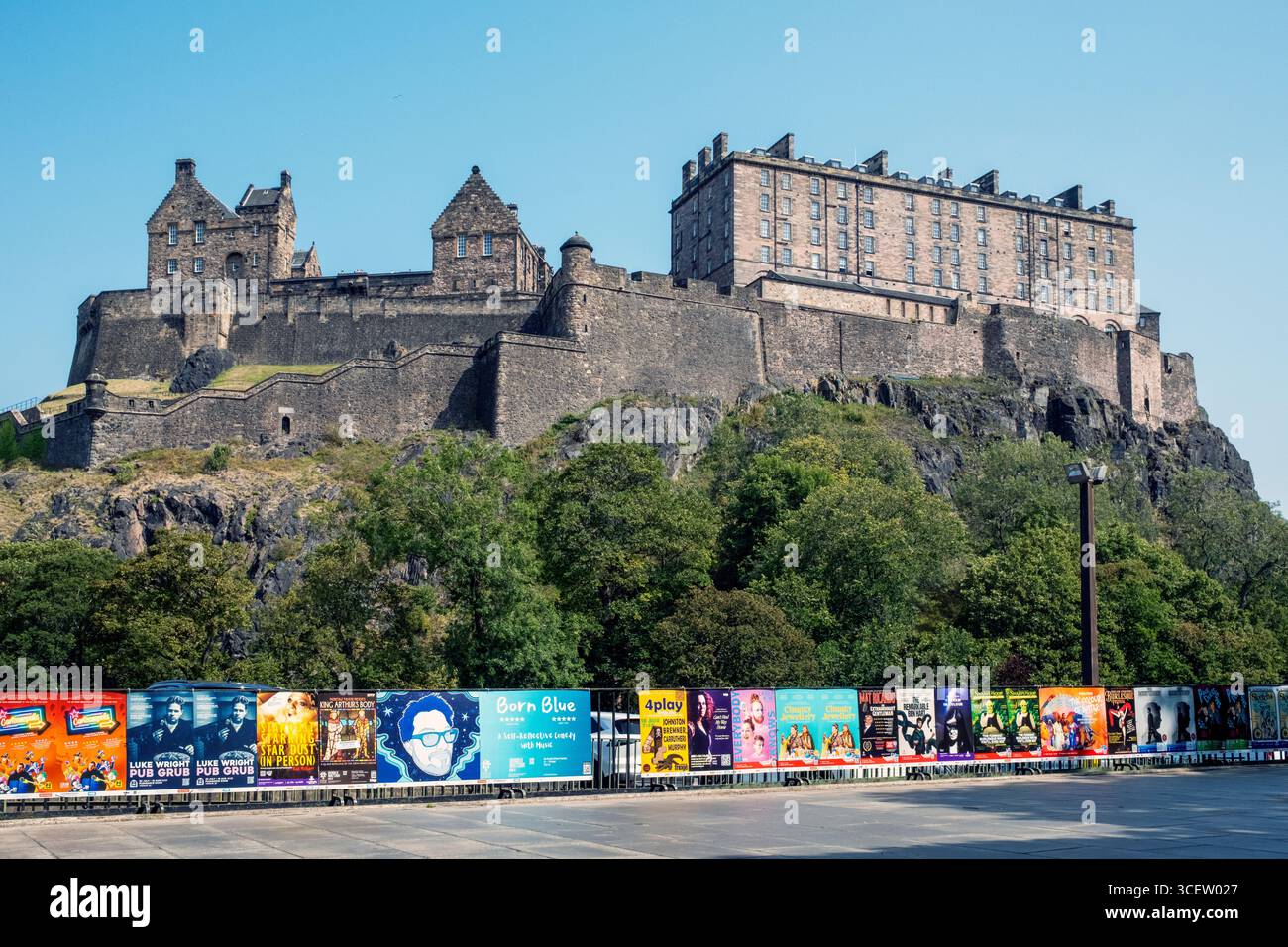 Edinburgh Castle von der Castle Terrace aus gesehen mit farbenfrohen Plakaten für das Edinburgh Festival Fringe im Vordergrund. Stockfoto