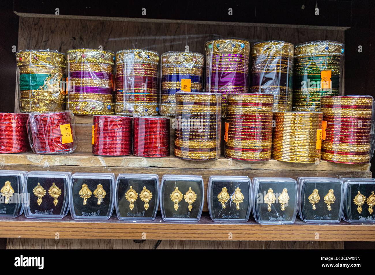 Glitzernde festliche Armreifen mit komplizierten goldenen Mustern auf Holzregal Stockfoto