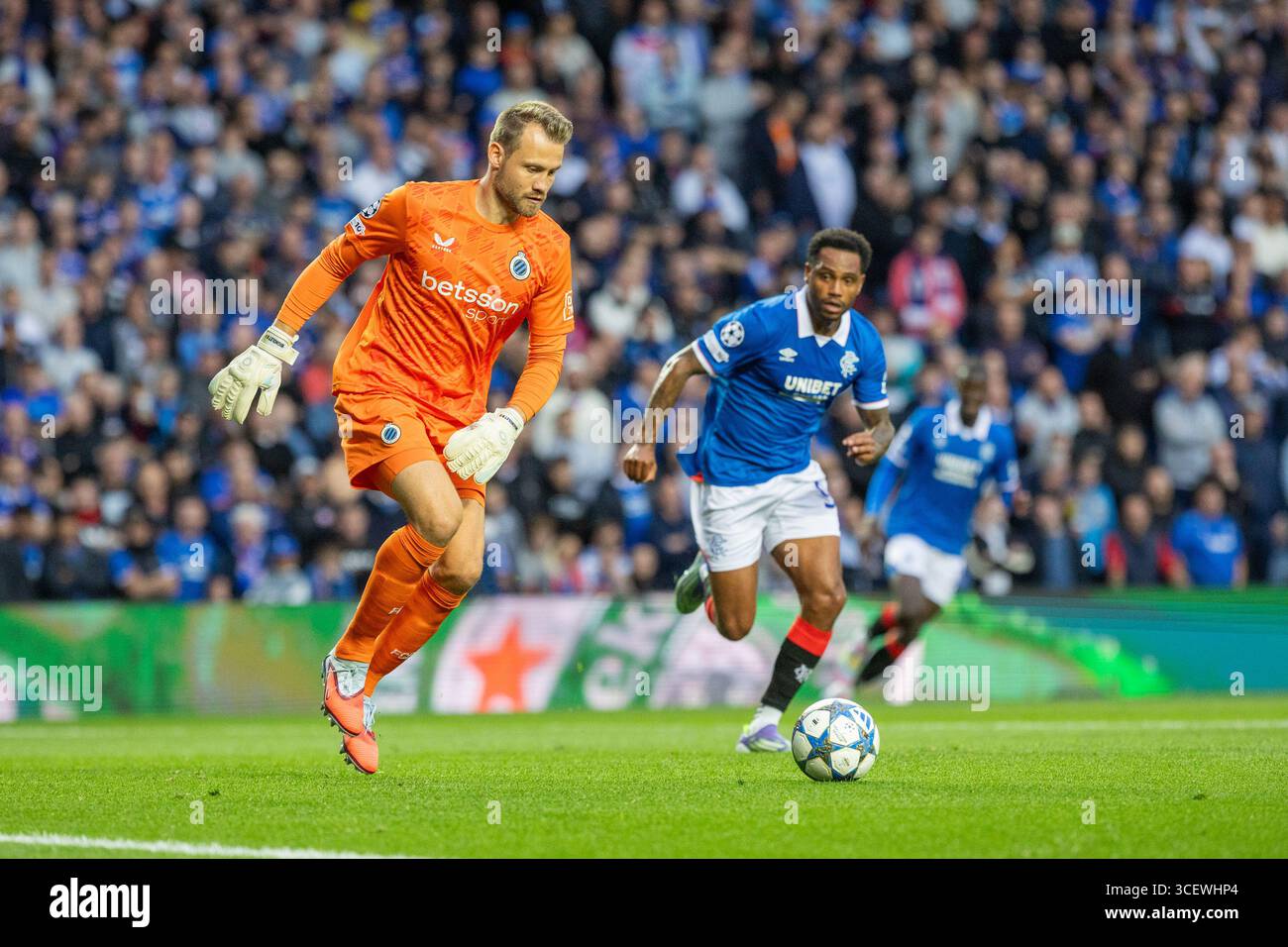 August 2025. Glasgow, Großbritannien. Rangers FC spielte Club Brugge FC im Ibrox-Stadion in Glasgow, Schottland, im ersten Leg der UEFA Champions League. Simon Mignolet, Brügge Torwart, tritt den Ball weg und wird von Danilo (R99) verfolgt. Quelle: Findlay / Alamy Live News Stockfoto