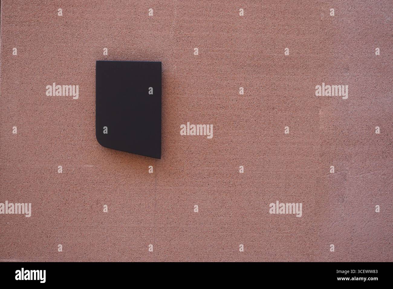 Die schwarze Form an der pinkfarbenen Wand sorgt für ein visuelles Interesse Stockfoto