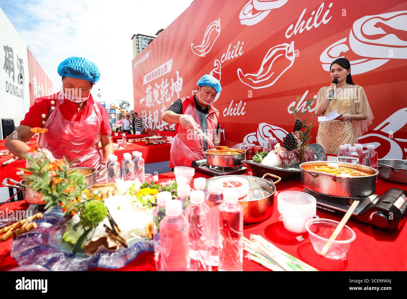 Die Teilnehmer werden bei einem Kochwettbewerb mit Chili-Küche als Hotpot gesehen. Zunyi, China. 18. August 2025. Die 10. Internationale Chili Expo in Guizhou (Zunyi) beginnt am 18. August 2025 im Xinpu New District in der Stadt Zunyi, Provinz Guizhou im Südwesten Chinas. Quelle: Qu Honglun/China News Service/Alamy Live News Stockfoto
