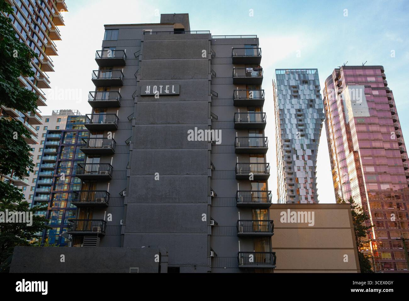 Divya Sutra Suites an der Robson Street in Vancouver. Dahinter befindet sich die einzigartige Architektur des Alberni Condominium. Stockfoto
