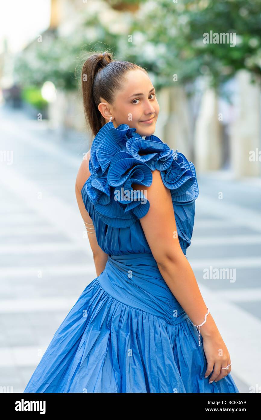 Schöne junge Frau, die draußen ein blaues Abendkleid trägt Stockfoto