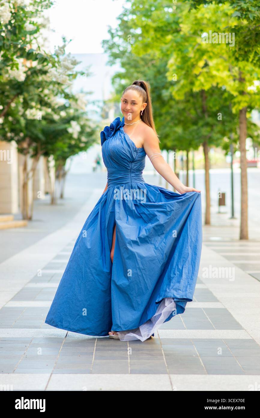 Schöne junge Frau, die draußen ein blaues Abendkleid trägt Stockfoto