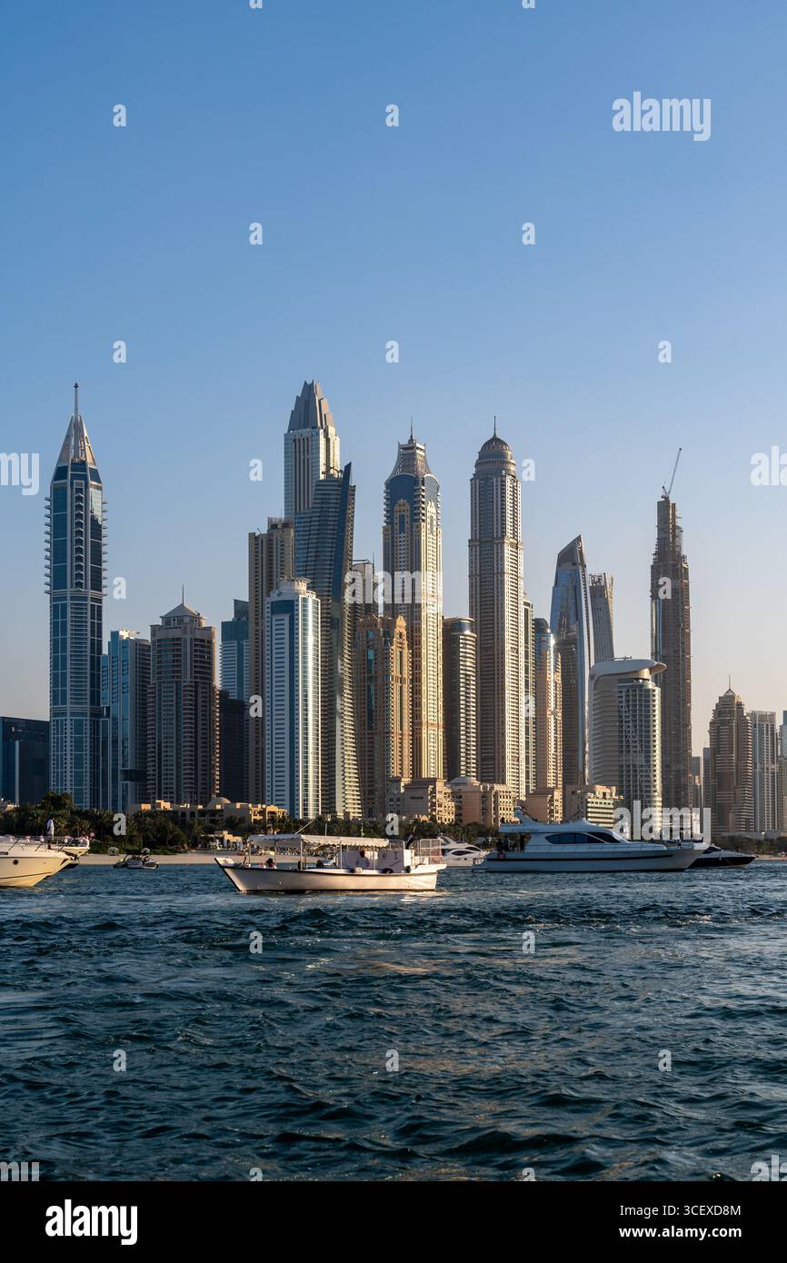 Dubai, Vereinigte Arabische Emirate - 17. März 2023: Wolkenkratzer und Boote an der Küste von Dubai bei Sonnenuntergang Stockfoto