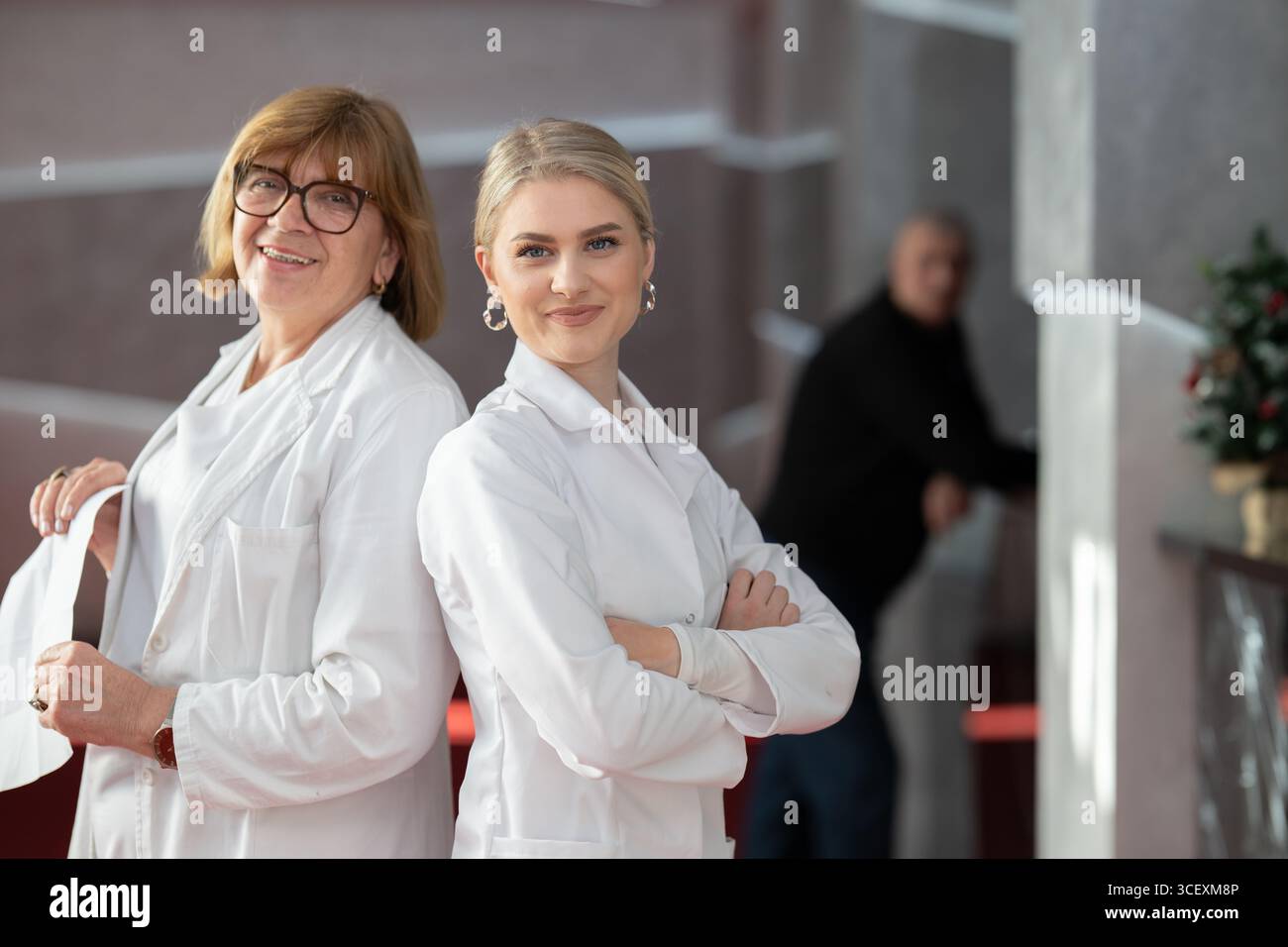 Gesundheitspersonal lächelt in der Klinik zurück an zurück Stockfoto