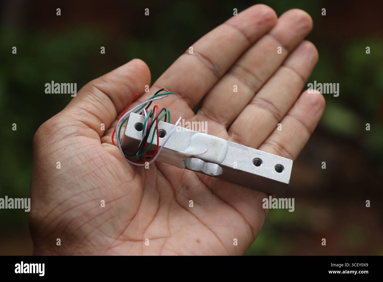 Kleines Wägezellen-Modul in der Hand für Hobby-Elektronikprojekte Stockfoto