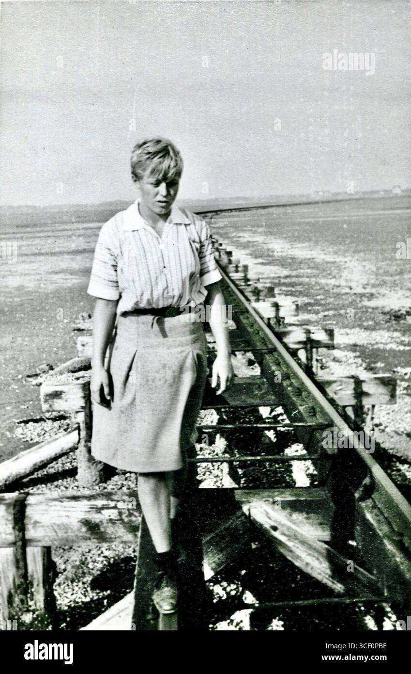 Beate Köstlin balancierte 1933 auf einer Schiene des Hochbahngleises von der Insel Juist. Dieses Foto zeigt sie bei Ebbe in der Nähe der Fähranlegestelle im Wattenmeer. Stockfoto