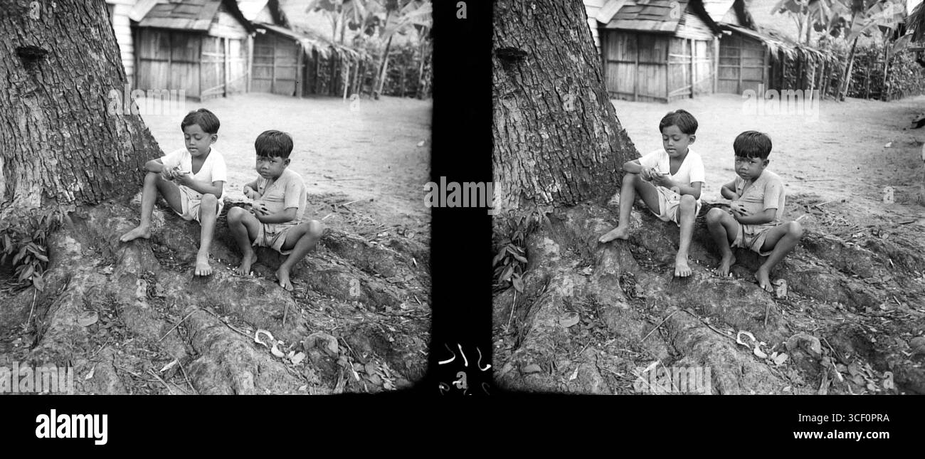 Ein stereoskopisches Bild von zwei javanischen Jungen mit einer Klatschpistole, aufgenommen zwischen 1930 und 1940. Das Foto zeigt das kulturelle Wesen von Java während dieser Zeit. Stockfoto