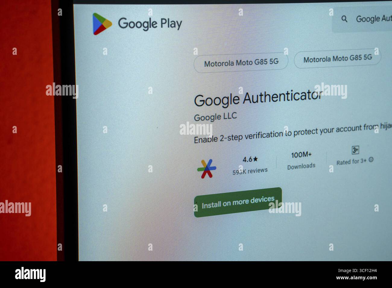 Google Authenticator wird auf der Google Play-Website mit Installationsoption und Überprüfungsdetails auf orangem Hintergrund angezeigt Stockfoto
