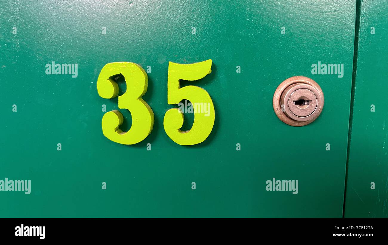 Grünes Schließfach mit der Nummer 35 mit Lochschlüsselkonzept Stockfoto