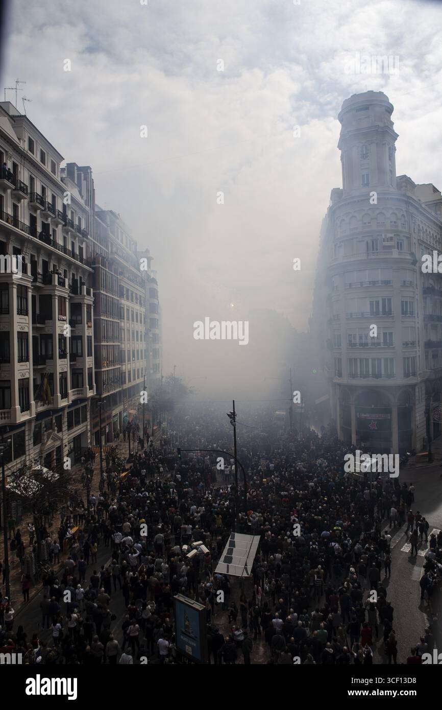 Dichte Menschenmassen durch eine nebelige Stadtstraße Mascleta de Fallas Stockfoto