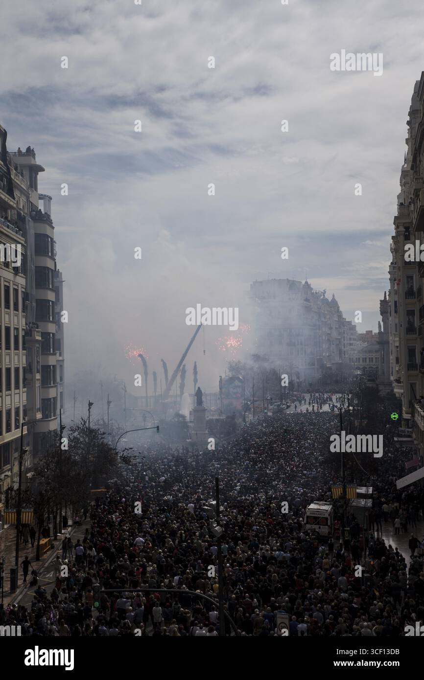 Dicht gepackte Menschenmenge unter Rauchwolken auf einer Stadtstraße Mascleta de Fallas Stockfoto