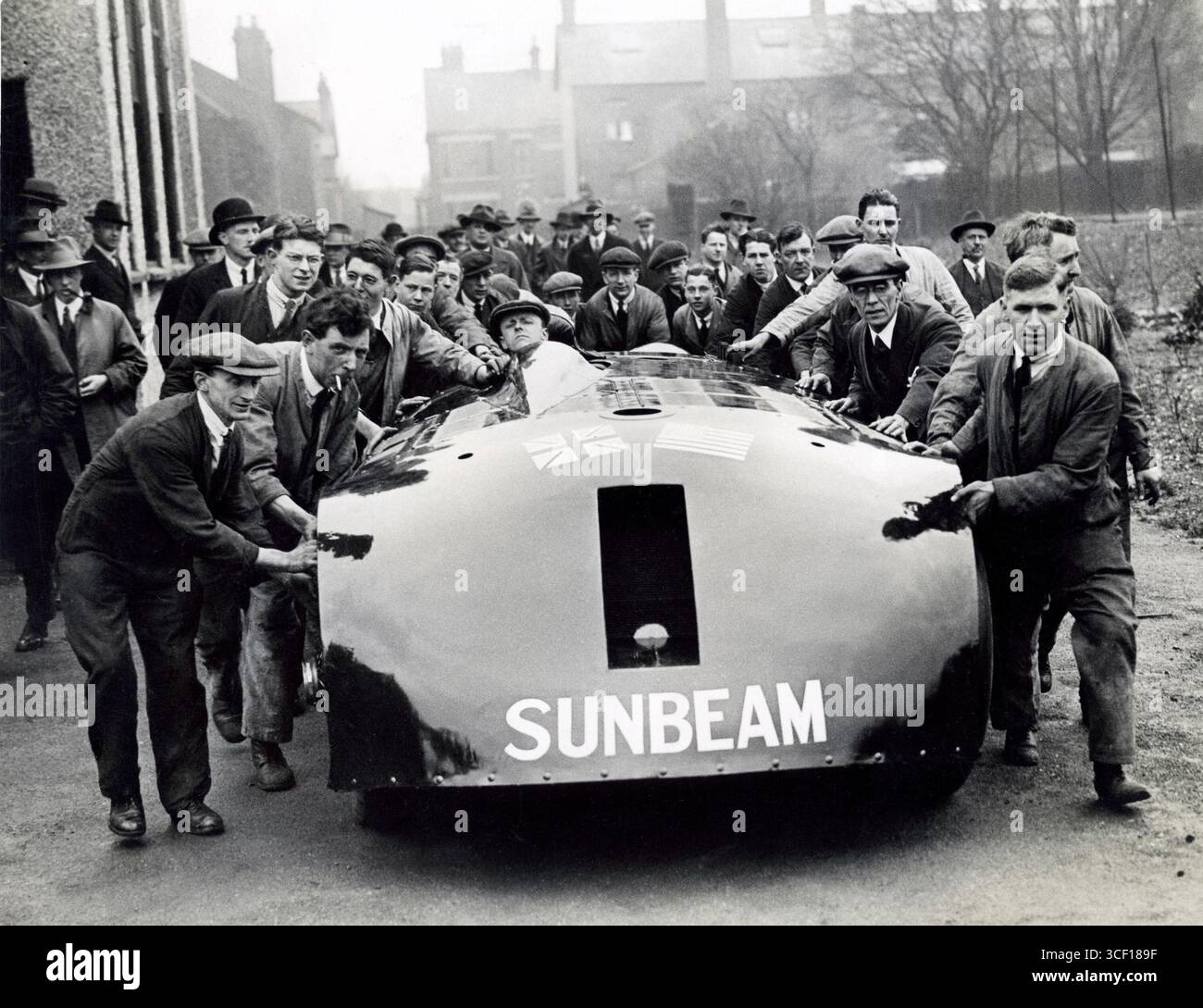 1927 reiste der britische Rennwagen Sunbeam in die Vereinigten Staaten, um einen Geschwindigkeitsrekord über eine Meile zu erreichen. Die Abbildung zeigt umstehende Personen, die bei der Fahrzeugbewegung helfen. Stockfoto