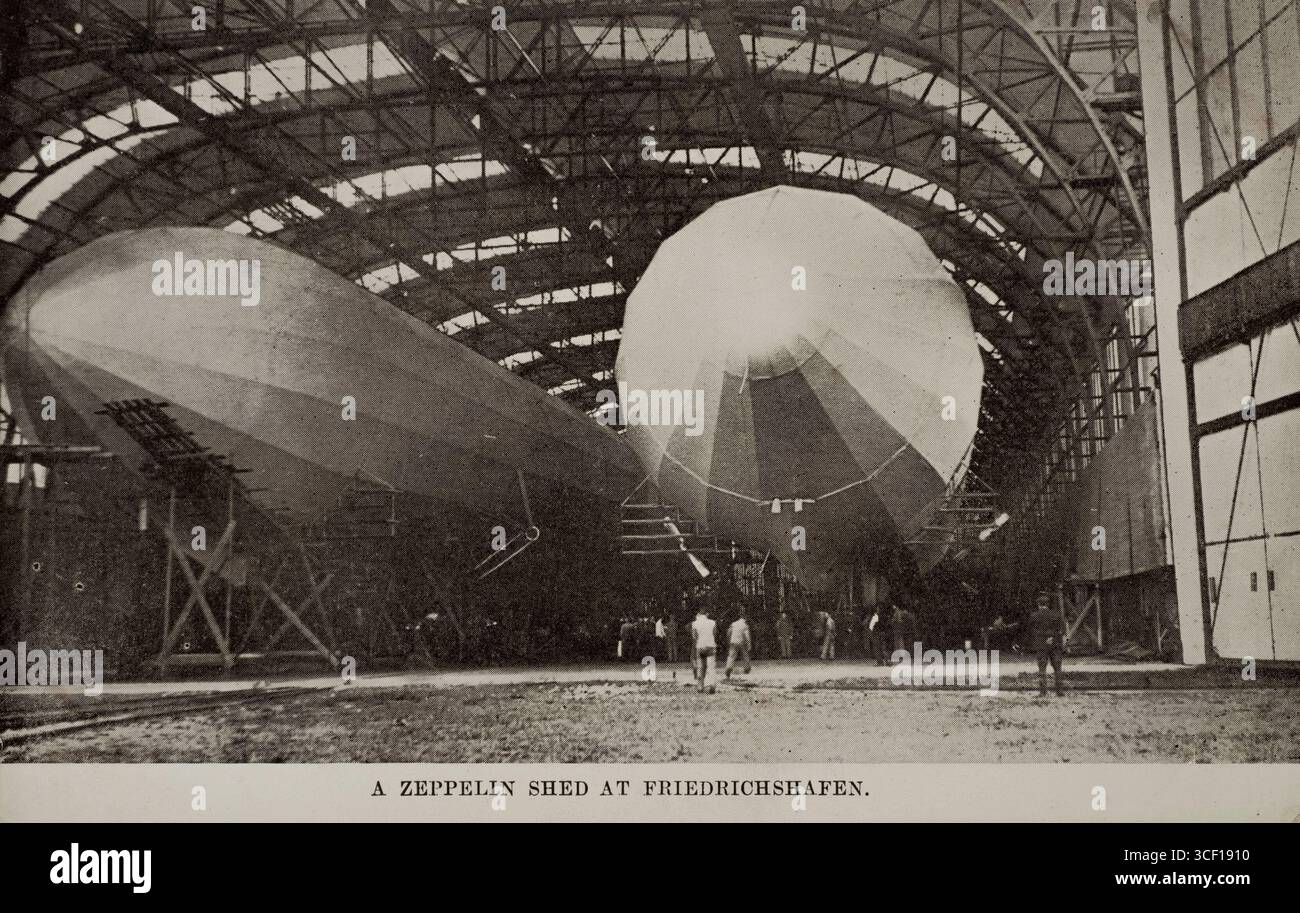 Eine Propagandakarte aus dem Ersten Weltkrieg, die 1914 in Friedrichshafen einen Hangar mit zwei Zeppelinen zeigt. Stockfoto