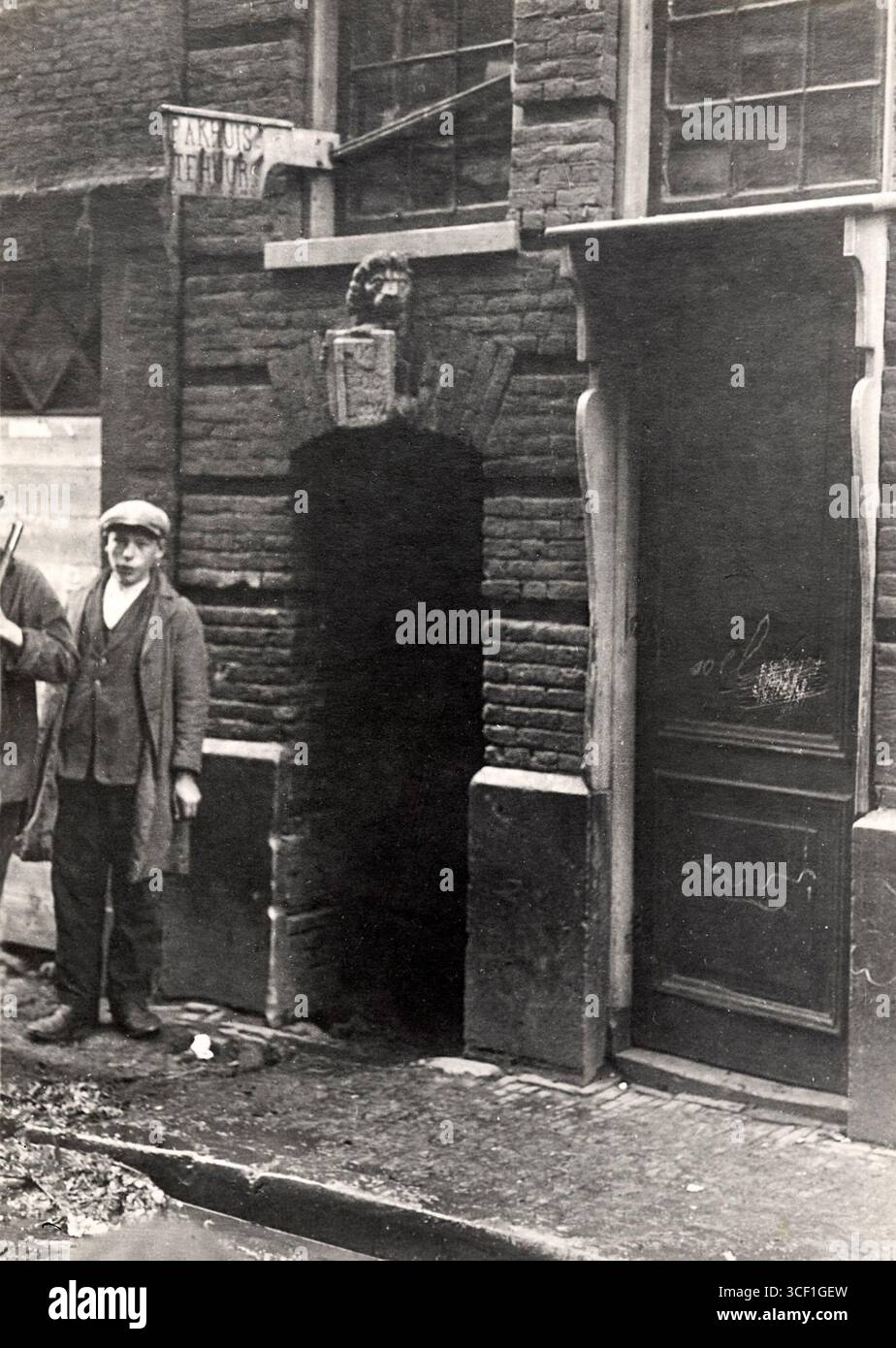 Ein jüdischer Junge steht vor dem Tor zur Red Lion Passage in der Valkenburgerstraat, Amsterdam. Das Foto zeigt ein jüdisches Viertel vor der Stadterneuerung im frühen 20. Jahrhundert. Stockfoto