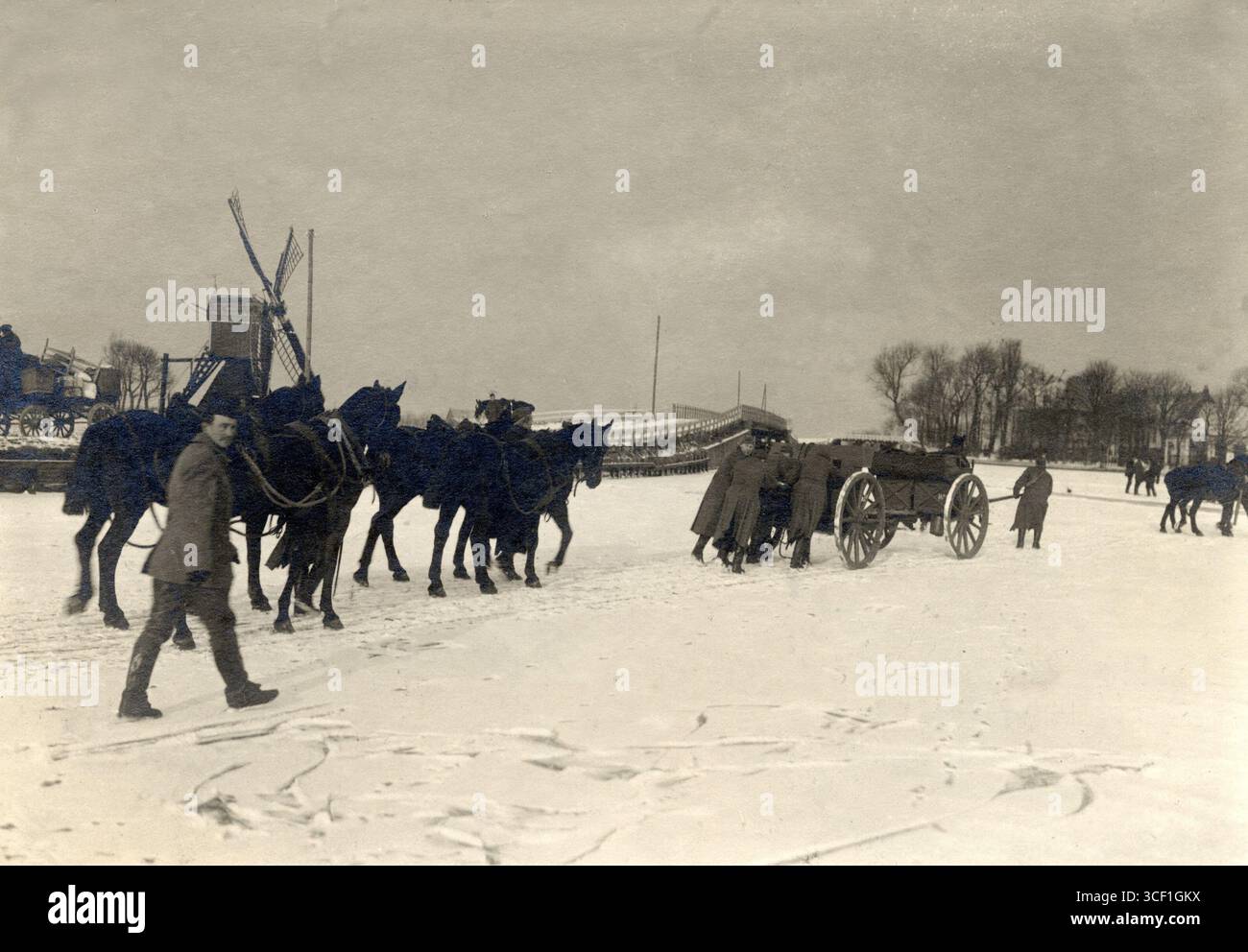 Im Februar 1917, während des Ersten Weltkriegs, ist die 7. Batterie des 4. Feldartillerie-Regiments unter dem Kommando von Lieutenant Trapman auf der eisigen Warmondsleede in Leiden stationiert. Im Hintergrund ist eine Windmühle zu sehen. Stockfoto