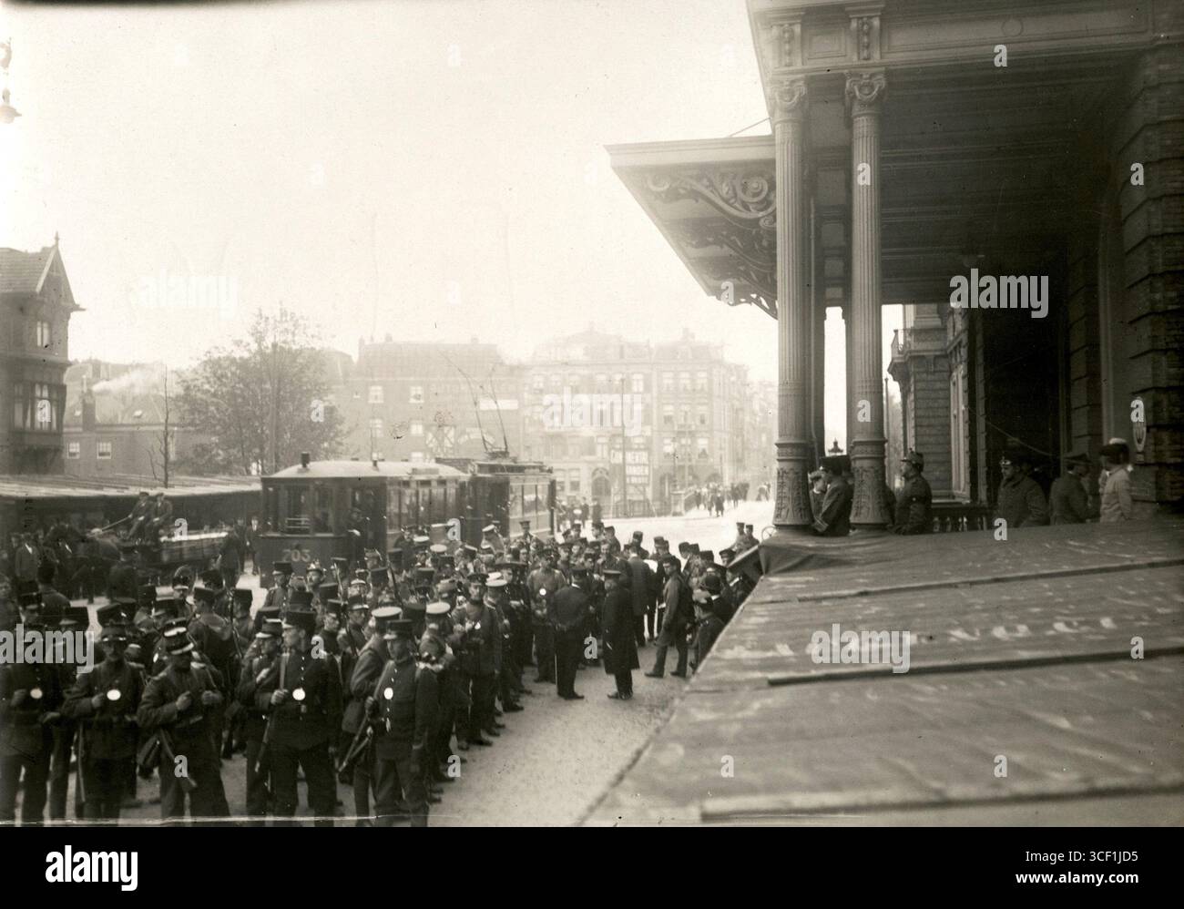 Eine große Gruppe niederländischer Soldaten in Uniform während eines dreitägigen militärmarsches entlang der Amsterdamer Verteidigungslinie, mit einer elektrischen Straßenbahn im Hintergrund, im Jahr 1915. Stockfoto