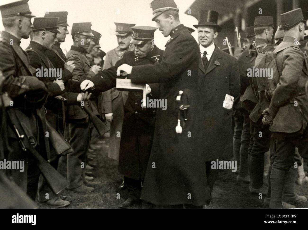 1915 erhält eine Gruppe niederländischer Soldaten in Uniform Erfrischungen von einem höheren Offizier während eines dreitägigen militärmarsches durch die Amsterdamer Verteidigungslinien. Stockfoto