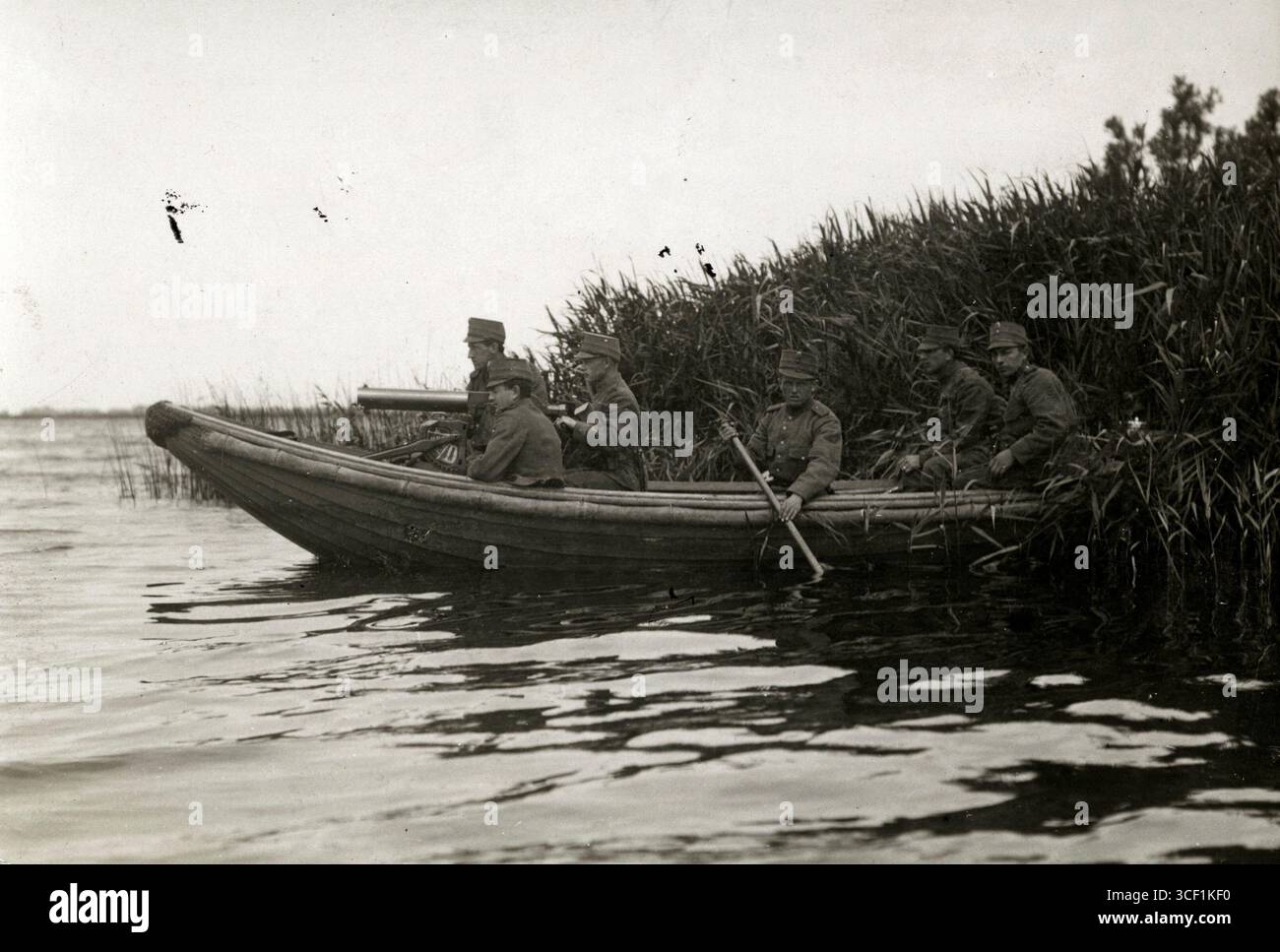 Niederländische Soldaten auf einem mit Motor und Maschinengewehr ausgestatteten Boot navigieren 1917 während einer militärischen Übung auf dem Kagermeer durch Schilf und simulieren Kriegsbedingungen. Stockfoto