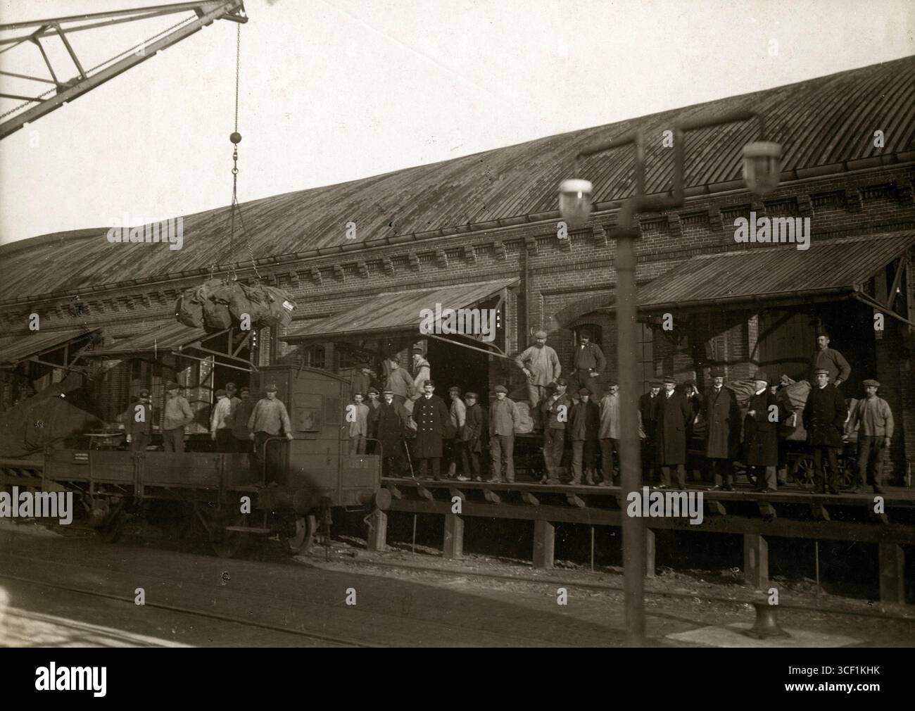 Eine Gruppe von Männern, darunter Hafenarbeiter, steht an einem Lagerhaus im Hafen von Hoek van Holland und bearbeitet Post für britische Kriegsgefangene während des Ersten Weltkriegs 1916. Stockfoto