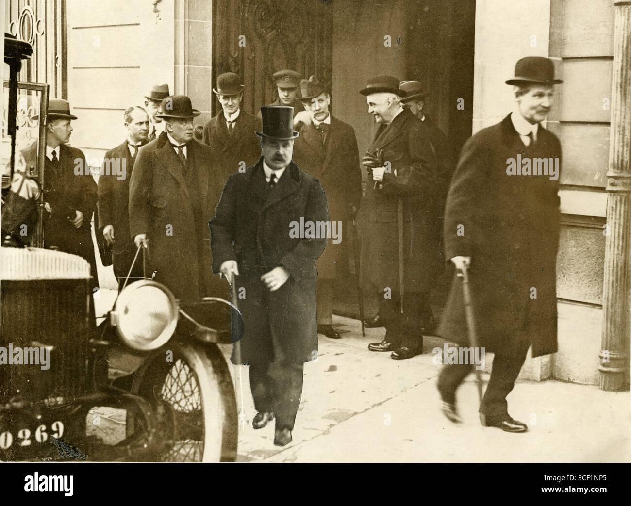 Die britische Delegation verlässt nach den Friedensverhandlungen im Jahr 1919 die vorübergehende Residenz von Lloyd George in Paris. Zu den wichtigsten Persönlichkeiten zählen Lloyd George, Bonar Law und James Balfour. Stockfoto