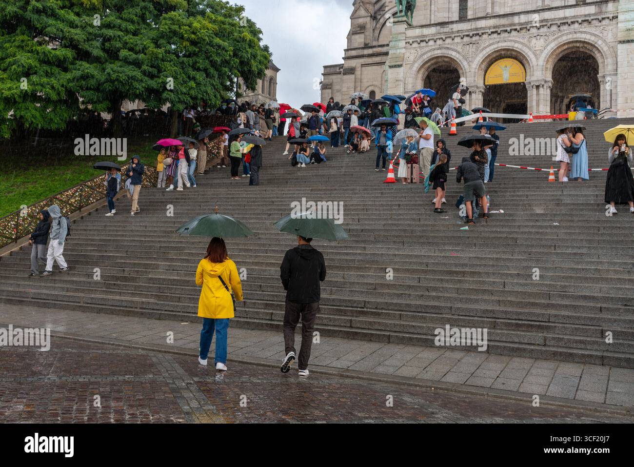 Leute mit Regenschirmen im starken Regen in Montmartre, dem 18. Arrondissement von Paris Stockfoto