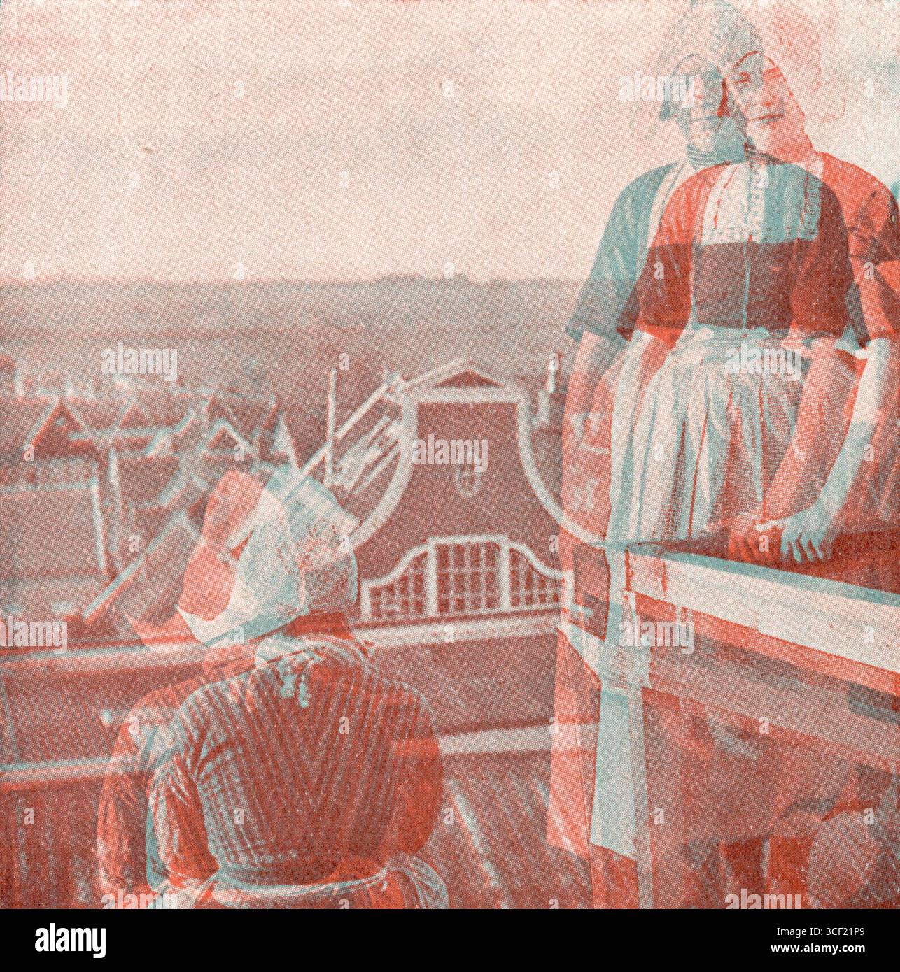 Volendam, Niederlande, 1924: Anaglyphe Stereophotographie des Dorfes mit zwei Frauen in traditioneller Kleidung auf einem Dach. Stockfoto