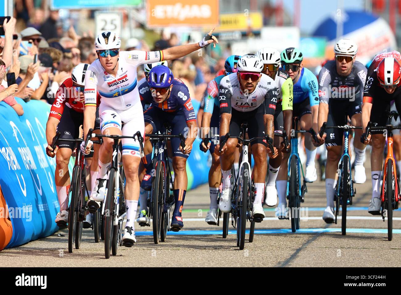 Breskens, Niederlande. August 2025. Der belgische Tim Merlier von Soudal Quick-Step (2L) überquert die Ziellinie, um zu gewinnen, bevor der belgische Arnaud de Lie vom Lotto Cycling Team (L) und der Kolumbianer Juan Sebastian Molano vom Team Emirates (C) am Mittwoch, den 20. August 2025, den Sprint beim Ziel der ersten Etappe des mehrstufigen Radrennens „Renewi Tour“ von Terneuzen nach Breskens, Niederlande (182 km). Das fünftägige Rennen findet in Belgien und den Niederlanden statt. BELGA FOTO DAVID PINTENS Credit: Belga News Agency/Alamy Live News Stockfoto
