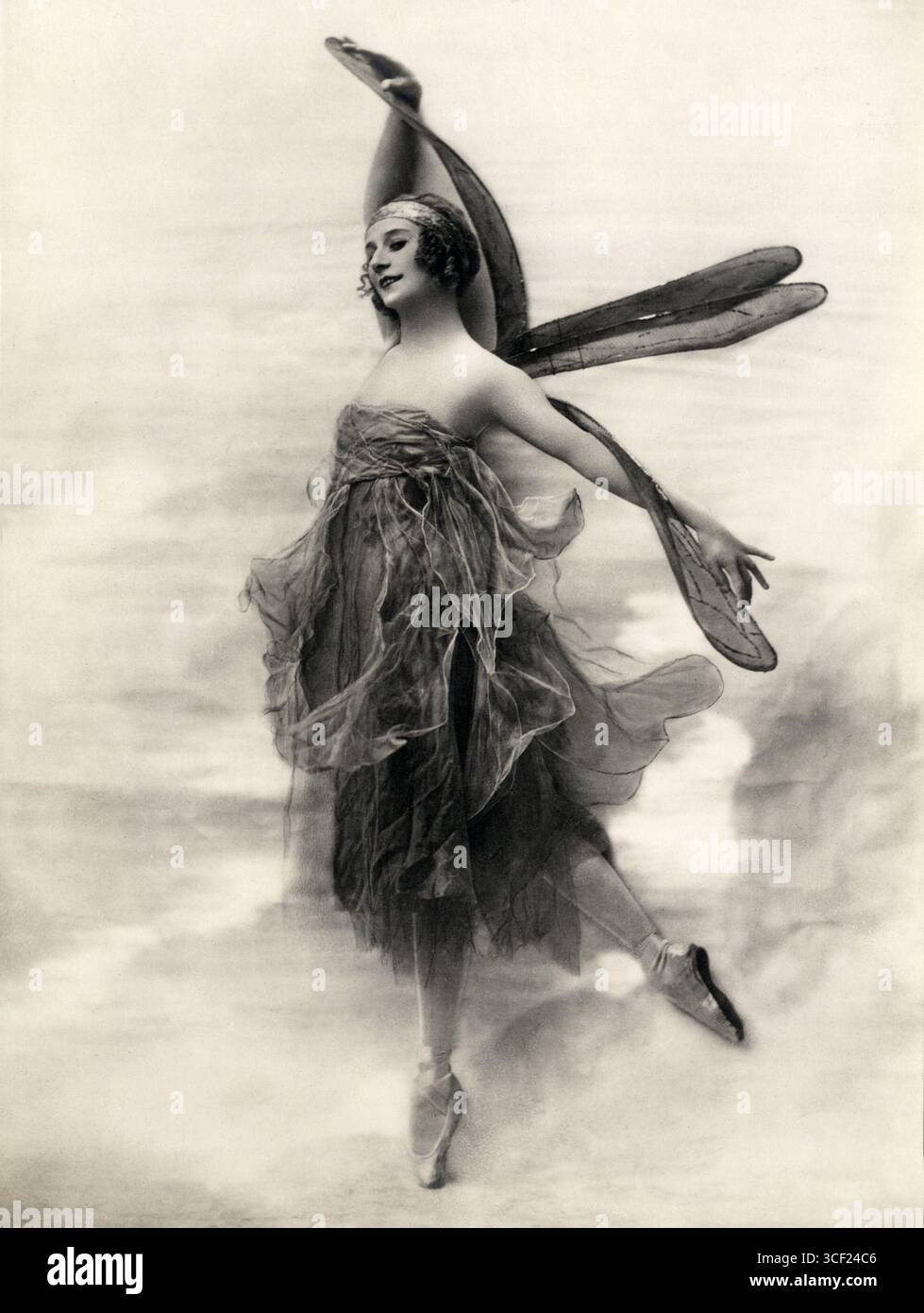 Anna Pavlova wird in einem Libellenkostüm auf pointe balanciert und zeigt die komplizierten und fantasievollen Kostüme, die um 1920 bei Ballettaufführungen verwendet wurden. Stockfoto
