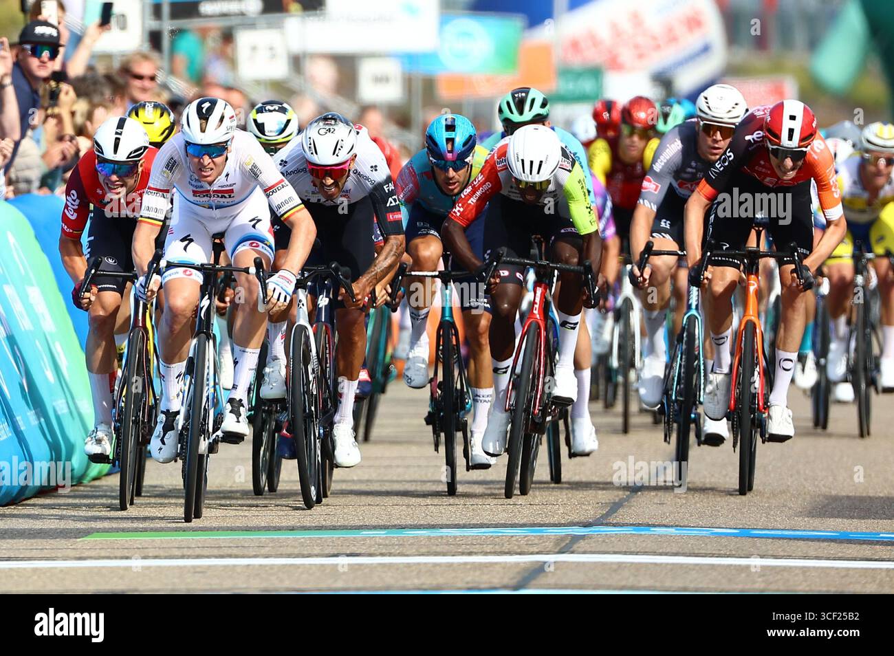 Breskens, Niederlande. August 2025. Der belgische Tim Merlier von Soudal Quick-Step (2L) überquert die Ziellinie, um zu gewinnen, bevor der belgische Arnaud de Lie vom Lotto Cycling Team (L) und der Kolumbianer Juan Sebastian Molano vom Team Emirates (3L) am Mittwoch, den 20. August 2025, den Sprint beim Ziel der ersten Etappe des mehrstufigen Radrennens „Renewi Tour“ von Terneuzen nach Breskens, Niederlande (182 km). Das fünftägige Rennen findet in Belgien und den Niederlanden statt. BELGA FOTO DAVID PINTENS Credit: Belga News Agency/Alamy Live News Stockfoto
