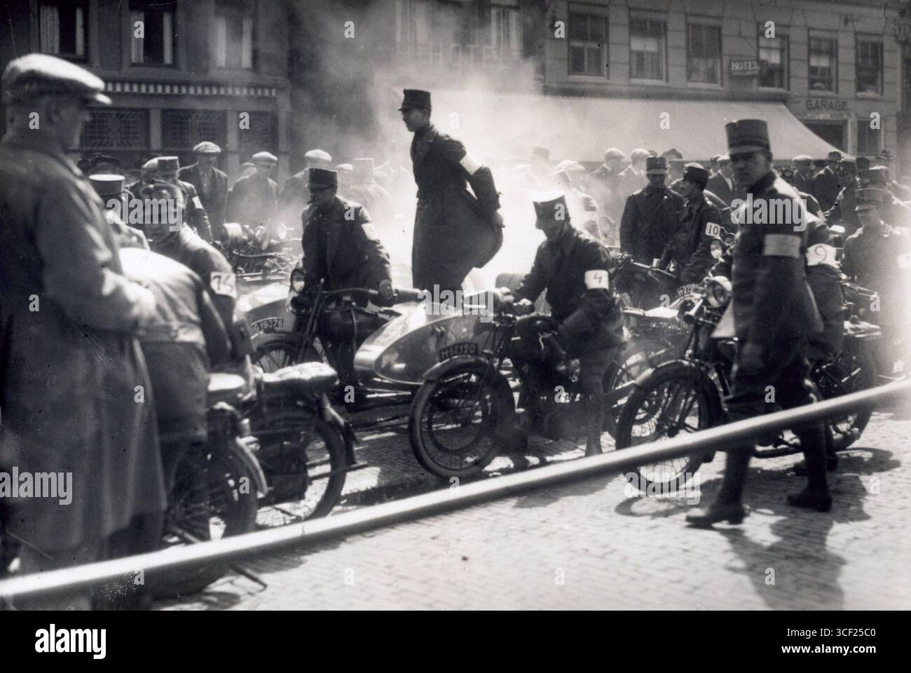 Der Beginn eines Motorradrennens für niederländische Soldaten um 1930. Das Bild zeigt das Militär, das sich auf ein Rennen vorbereitet, und zeigt seine Fahrzeuge und Uniformen der damaligen Zeit. Stockfoto