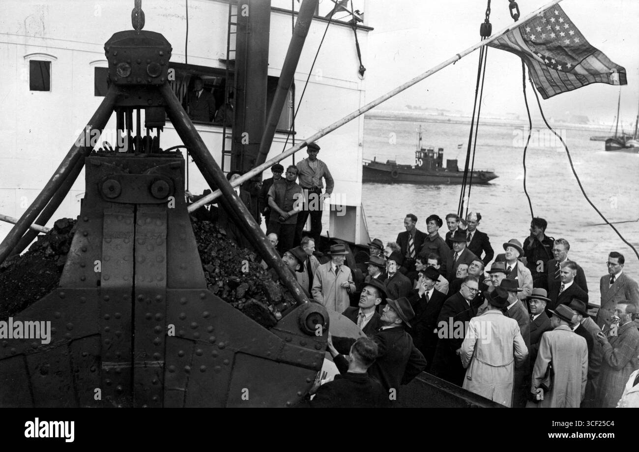 Im September 1948, während des Wiederaufbaus der Nachkriegszeit, kommt die erste Kohlelieferung des Marshallplans in Coenhaven, Amsterdam, an Bord des Schiffes „de Stad Vlaardingen“ an, das von H. Wemmers, dem Direktor des Rijkskolenbüros, empfangen wurde. Stockfoto