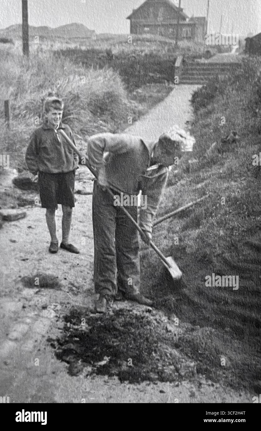 Der zwölfjährige Schüler Hagen Distelbarth beobachtet Dr. Wolfgang Luther an der Schule am Meer, einem progressiven Internat auf der ostfriesischen Insel Juist. Distelbarth, geboren 1918, diente später als erster Leutnant in der deutschen Luftwaffe während des Zweiten Weltkriegs und wurde 1941 im Einsatz getötet. Dr. Luther, geboren 1903 in Moskau, war Lehrer an der Schule. Die sichtbare Struktur im Hintergrund ist das Café zur freien Aussicht. Stockfoto