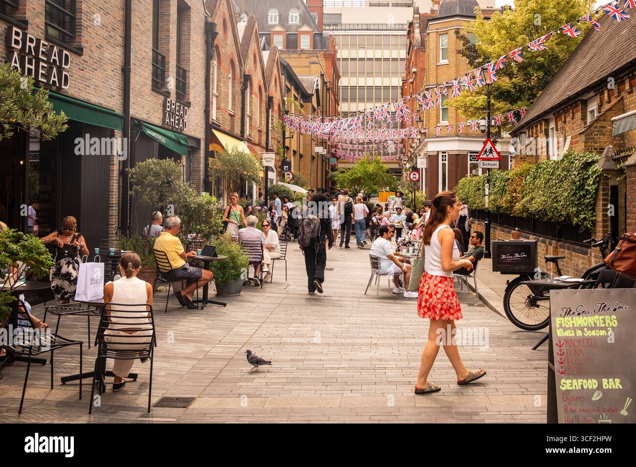 LONDON, 13. AUGUST 2025: Shopper und Schaufenster am Sloane Square, einem exklusiven Einkaufsziel im Südwesten Londons Stockfoto
