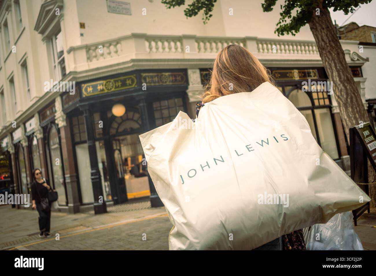 LONDON, 13. AUGUST 2025: Shoppers on the Kings Road with John Lewis Shoppers Stockfoto