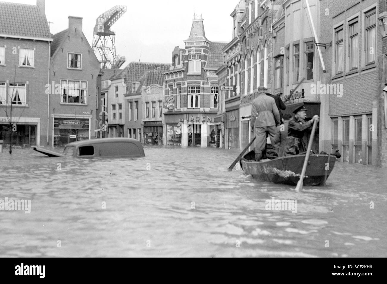 Eine Szene aus den Überschwemmungen von 1953 in Vlissingen, die ein Boot zeigt, das im Februar 1953 durch die Walstraat und den Kleinen Markt fährt. Dieses Bild zeigt die schwere Überschwemmung, die durch die Katastrophe verursacht wurde. Stockfoto