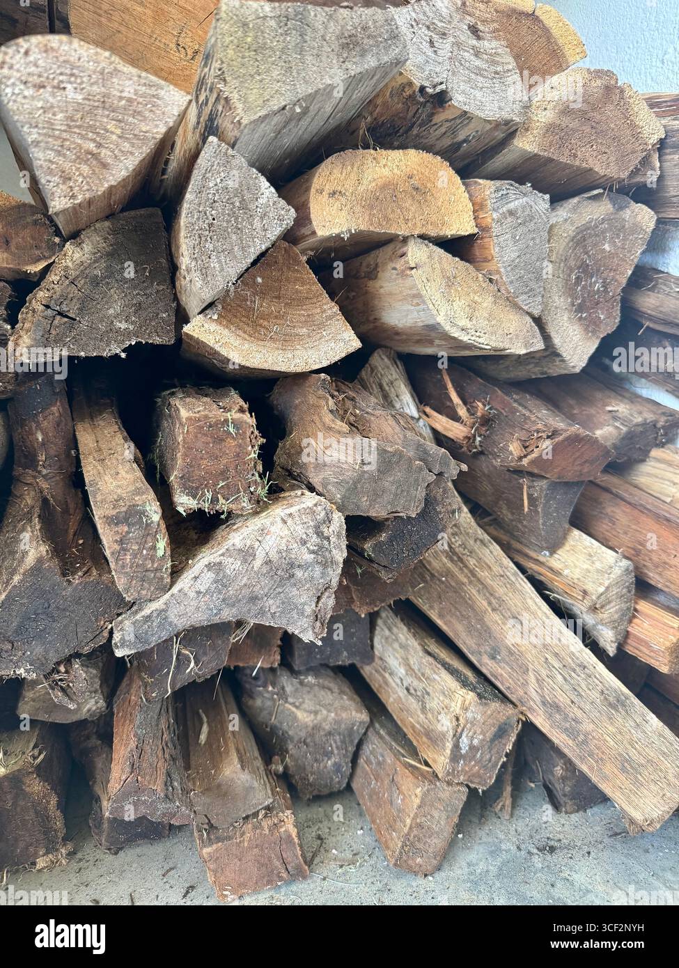 Stapel gehackten Brennholzes, der für die Lagerung oder Verwendung in einem Kamin oder Holzofen vorbereitet ist. - Smartphone-aufgenommenes Stockfoto