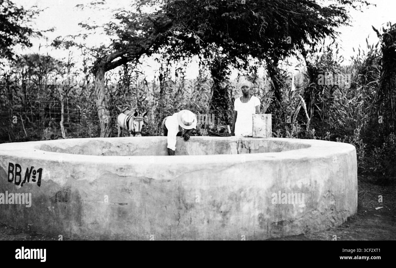 Dieses Bild ist ein Repronegativ aus der Zeit von 1920 bis 1950 mit dem Titel „Twee mensen halen Water uit een Waterput“. Das Foto, aufgenommen von einem unbekannten Fotografen, zeigt zwei Menschen, die Wasser aus einem Brunnen ziehen. Die Größe des Werkes beträgt 9 x 12 cm (9/16 x 3/4 Zoll). Stockfoto