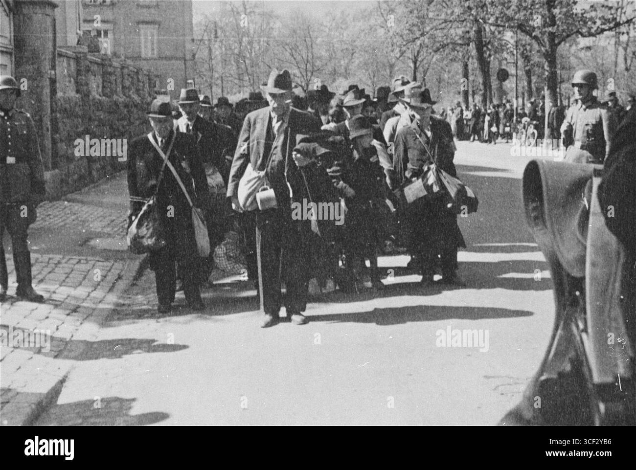 Dieses Foto zeigt Juden, die am 25. April 1942 aus Würzburg deportiert wurden und entlang der Hindenburgstraße in Richtung Bahnhof marschierten. Die Deportation war Teil der umfassenderen Bemühungen des Nazi-Deutschlands, jüdische Menschen während des Holocaust aus ihren Häusern zu entfernen. Stockfoto