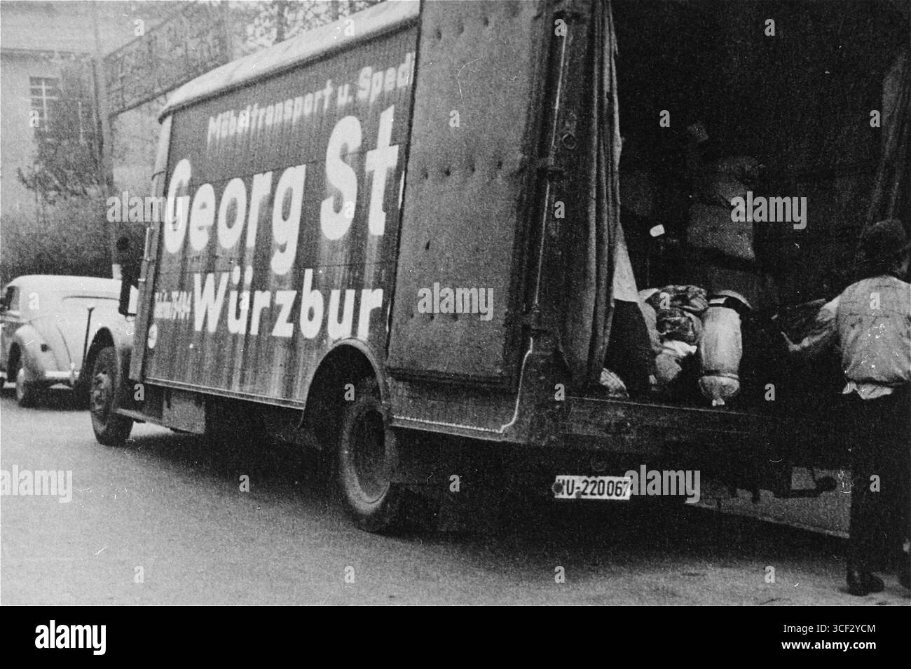 Eine Gruppe von Juden, die aus Würzburg deportiert wurden, kann 1942 gesehen werden, wie sie ihre Habseligkeiten in einen Van luden, ein tragischer Teil des umfassenderen Prozesses der Vertreibung und Verfolgung während des Holocaust unter Nazi-Kontrolle. Stockfoto