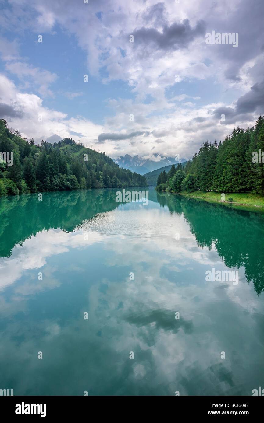 Centro Cadore Lake nach dem Frühlingsregen mit bewölktem Himmel und bewaldeten Berggipfeln. Domegge di Cadore, Provinz Belluno, Venetien, Norditalien Stockfoto