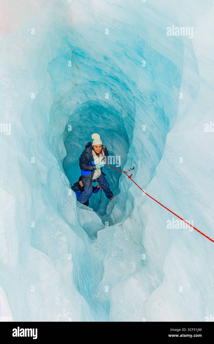 Bergsteiger, der die Eishöhle hinaufzieht, Fox Glacier, Westland National Park, South Island, Neuseeland Stockfoto