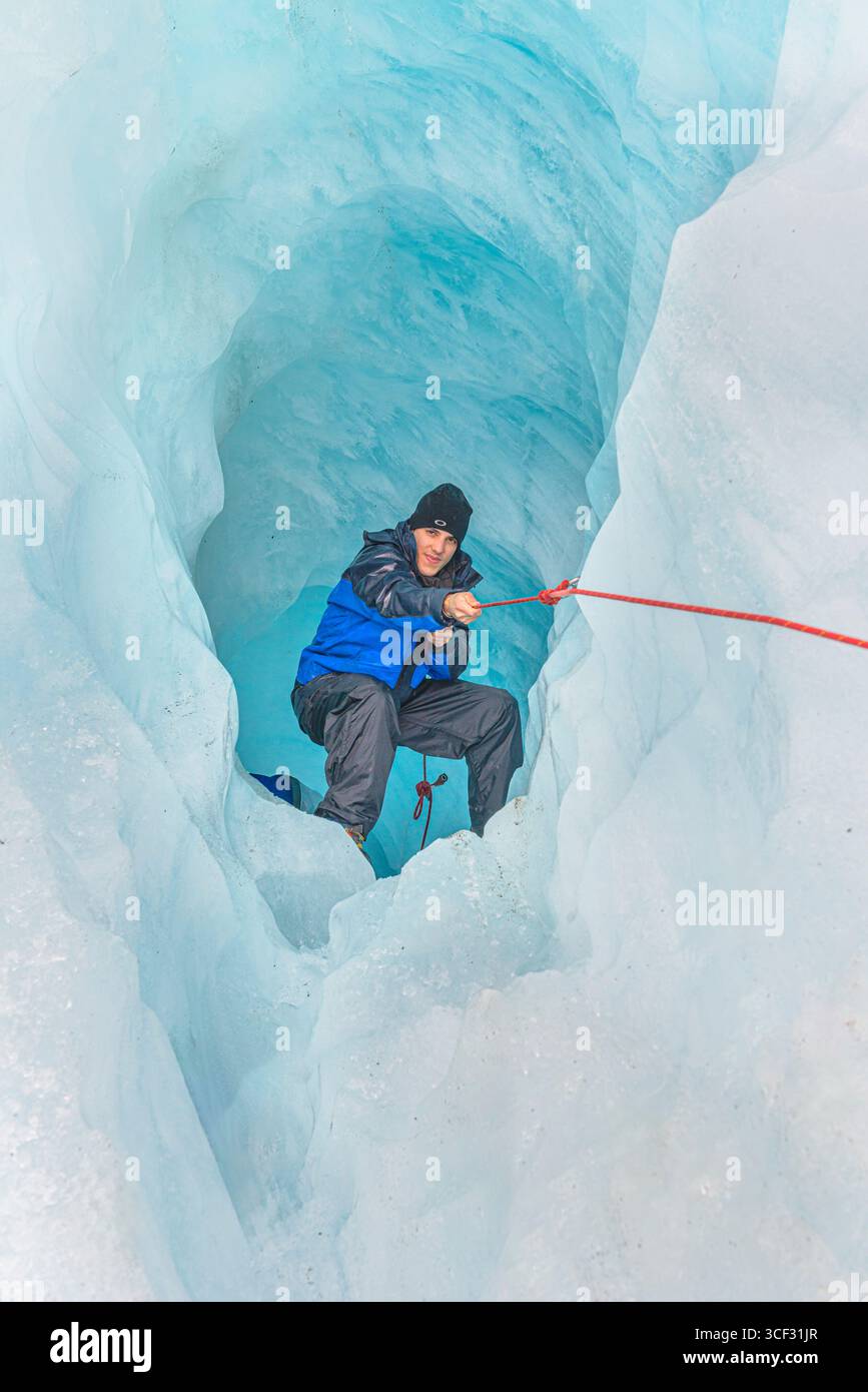 Bergsteiger, der die Eishöhle hinaufzieht, Fox Glacier, Westland National Park, South Island, Neuseeland Stockfoto