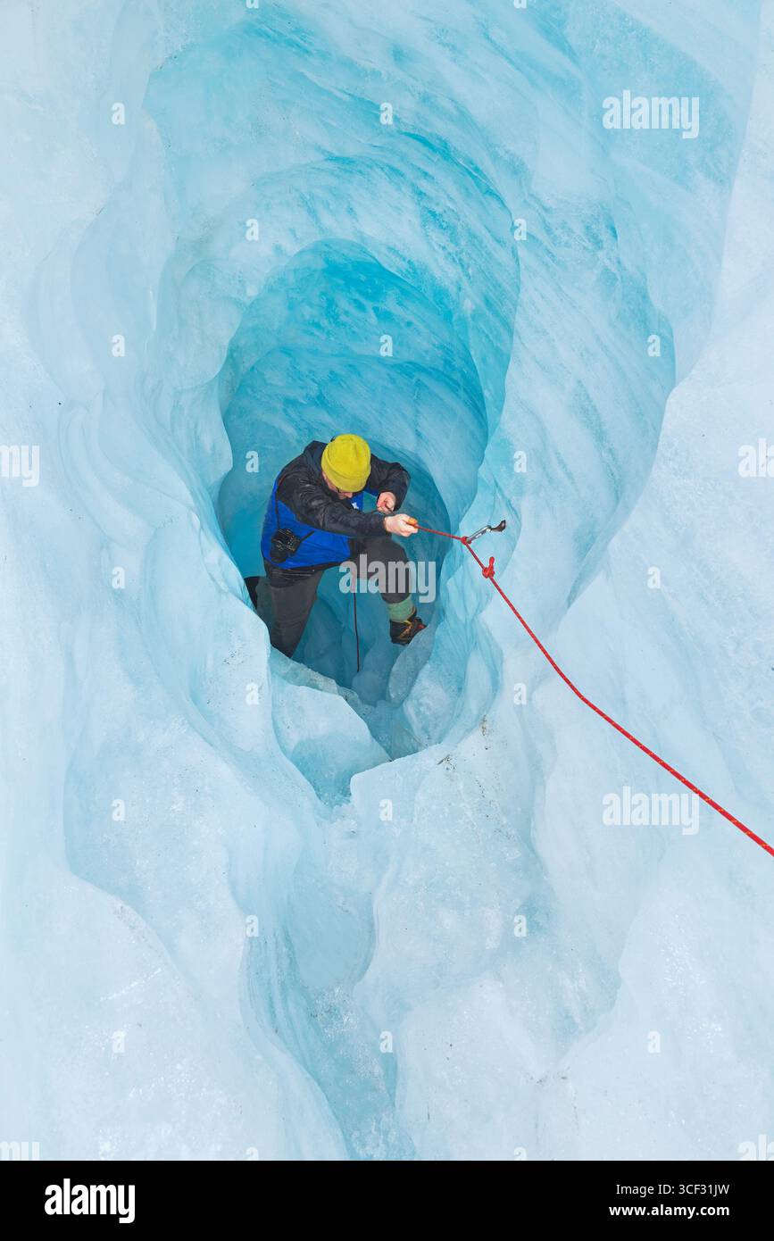 Bergsteiger, der die Eishöhle hinaufzieht, Fox Glacier, Westland National Park, South Island, Neuseeland Stockfoto