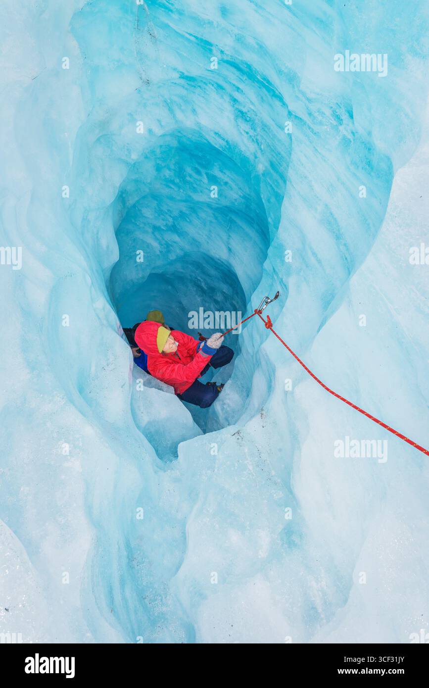 Bergsteiger, der die Eishöhle hinaufzieht, Fox Glacier, Westland National Park, South Island, Neuseeland Stockfoto