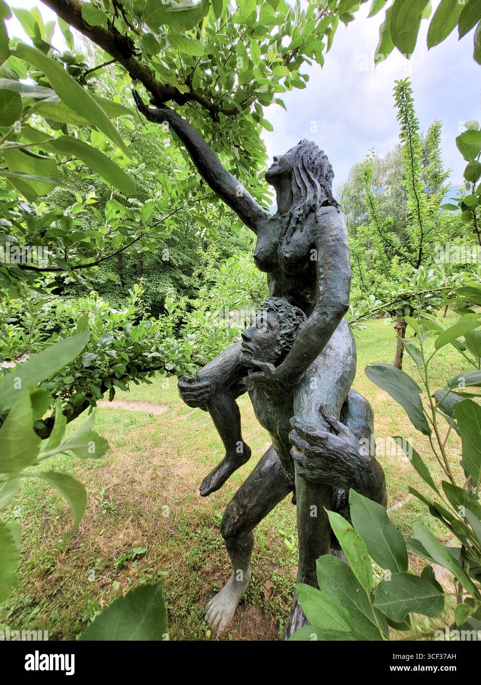 Bronzestatuen von Adam und Eva auf einem Apfelbaum, Gärten von Schloss Trauttmansdorff, Meran, Südtirol, Italien, Europa Stockfoto