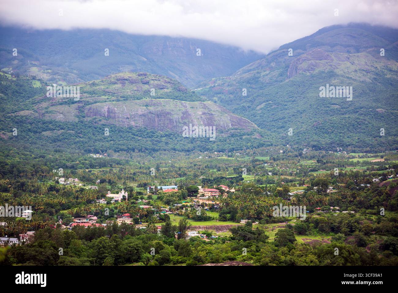 Aus der Vogelperspektive auf ein wunderschönes Walddorf in der Nähe der Berge in Kanthalloor, Munnar, Kerala, Indien. Die malerische Landschaft bietet üppiges Grün und Nebel Stockfoto
